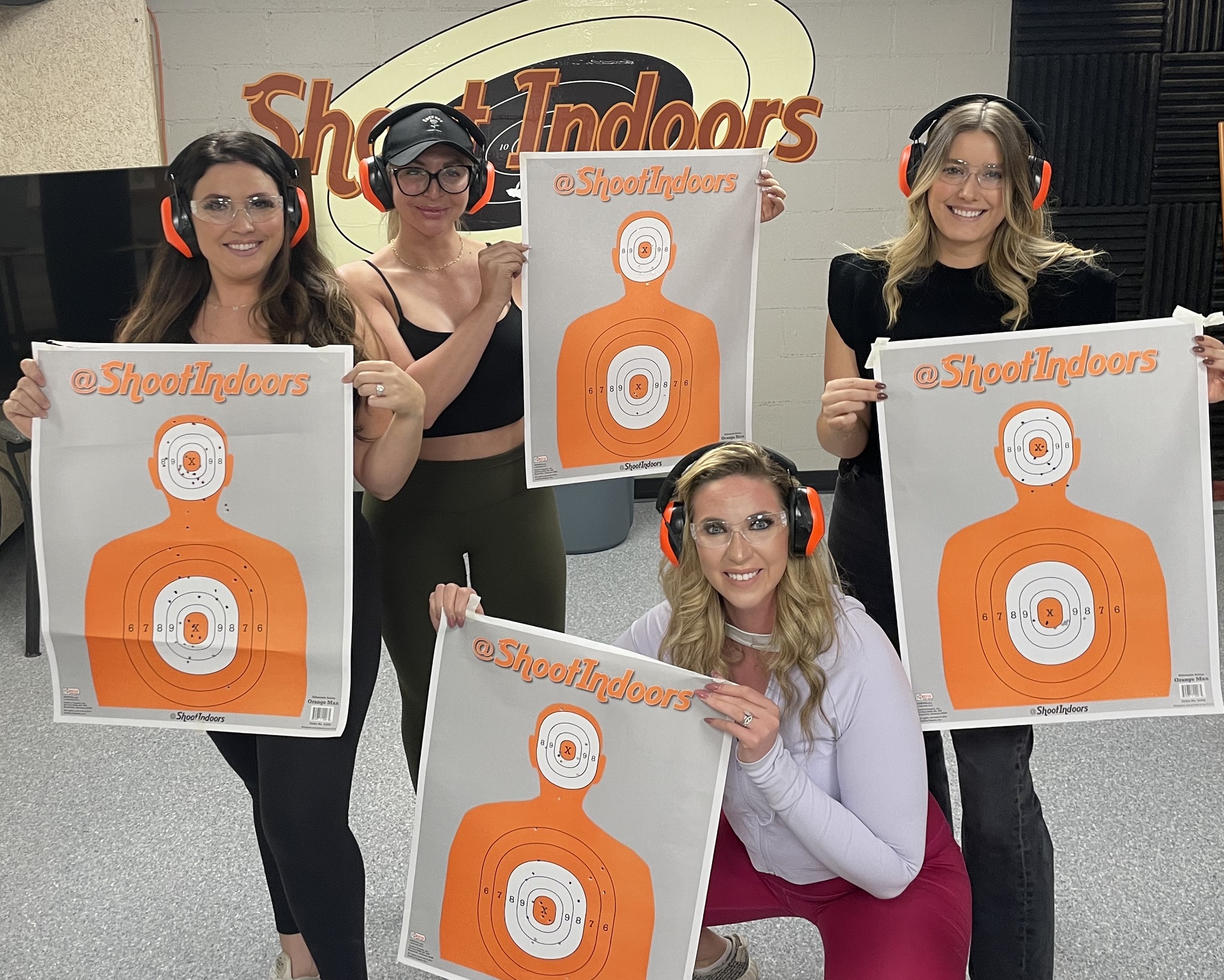 Happy customers holding their targets at Shoot Indoors